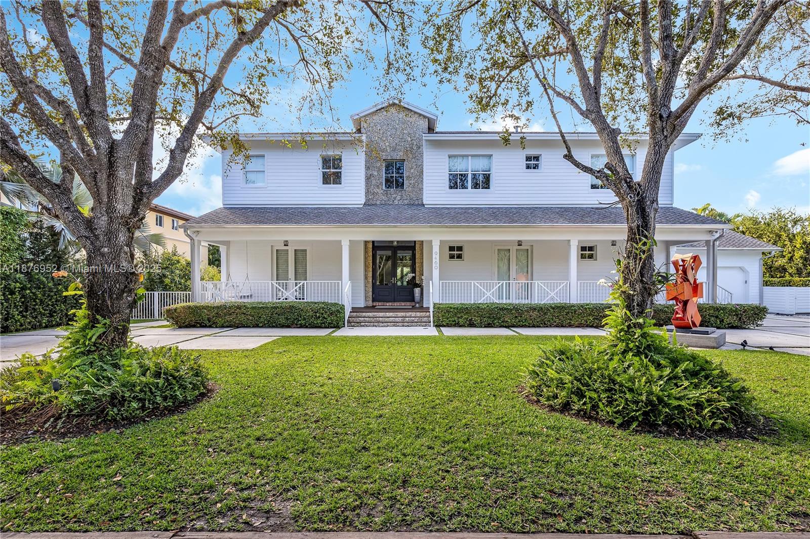 a front view of a house with a garden and trees
