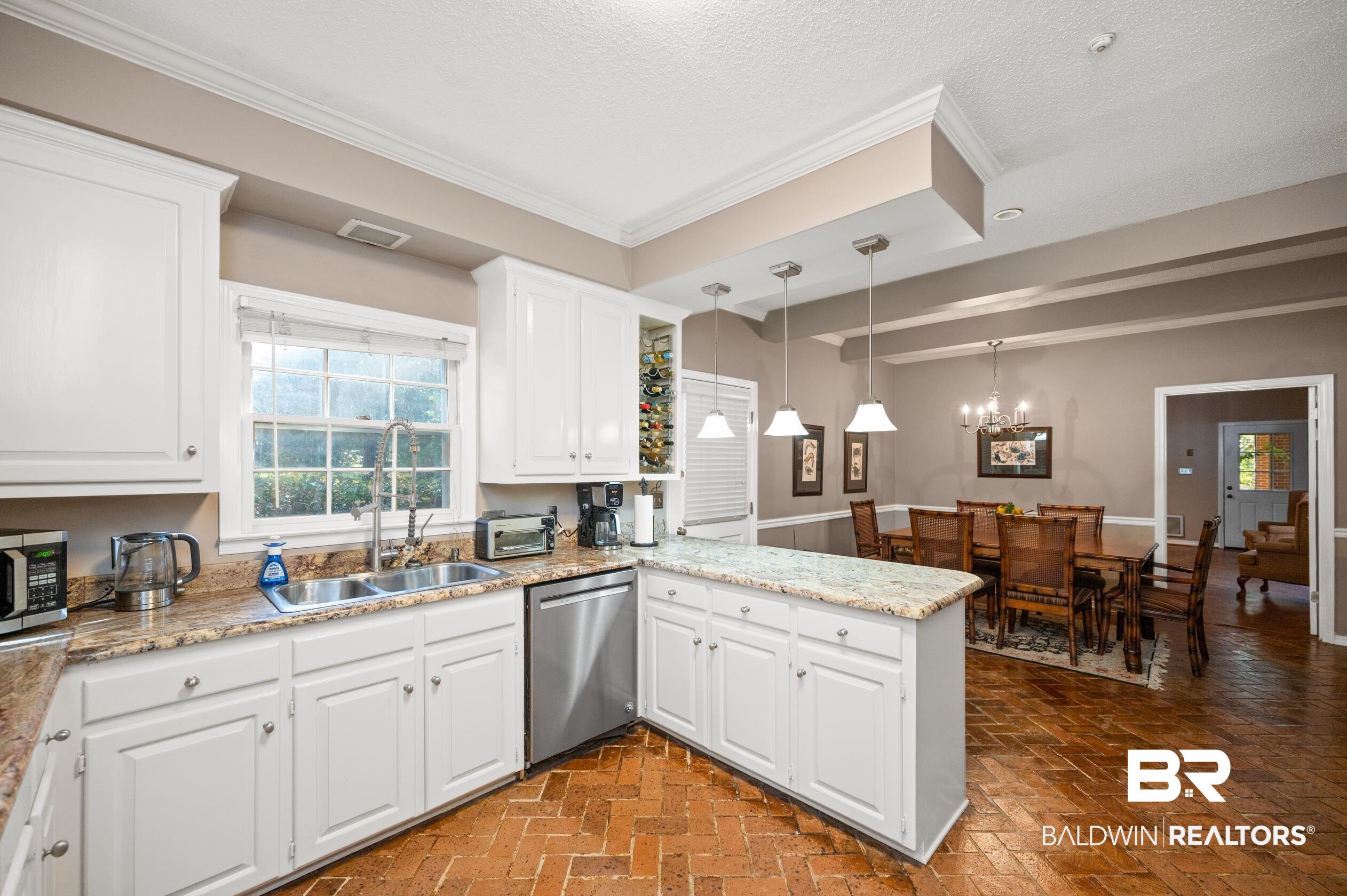6705 Ridgeland Road South Mobile, AL 36695 - Photo 10 of 44 Kitchen with hanging light fixtures, kitchen peninsula, sink, white cabinets, and appliances with stainless steel finishes