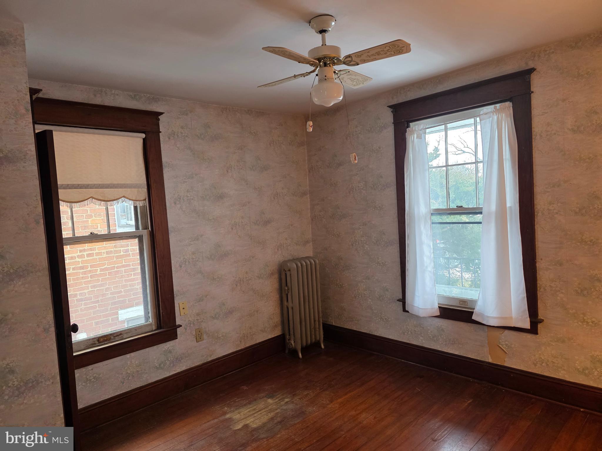 104 East 7th Street Frederick, MD 21701 - Photo 17 of 28 an empty room with wooden floor chandelier fan and windows
