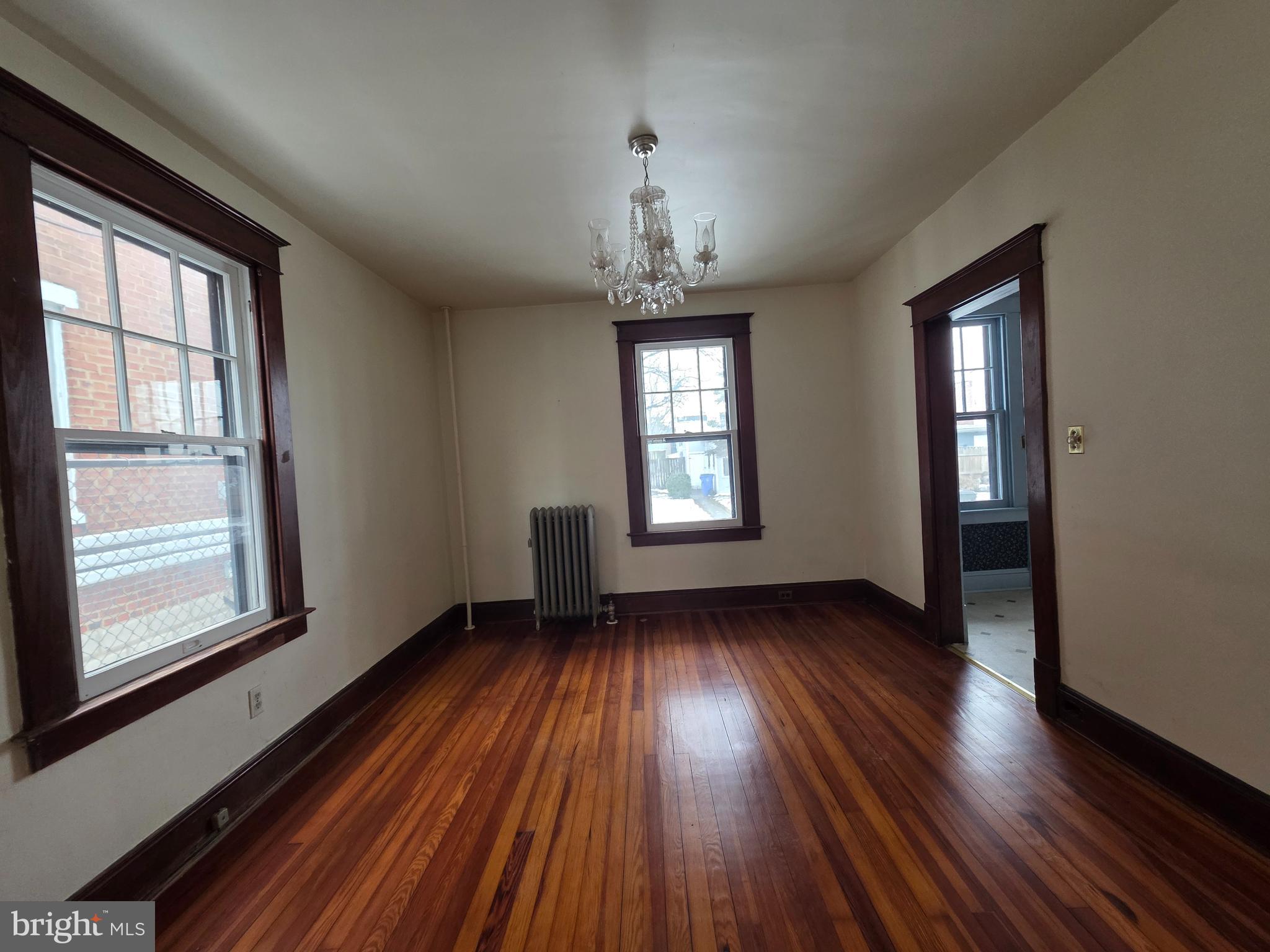104 East 7th Street Frederick, MD 21701 - Photo 9 of 28 an empty room with wooden floor windows and entrance