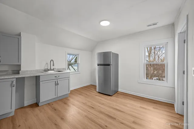 a kitchen with stainless steel appliances granite countertop a refrigerator sink and wooden floor