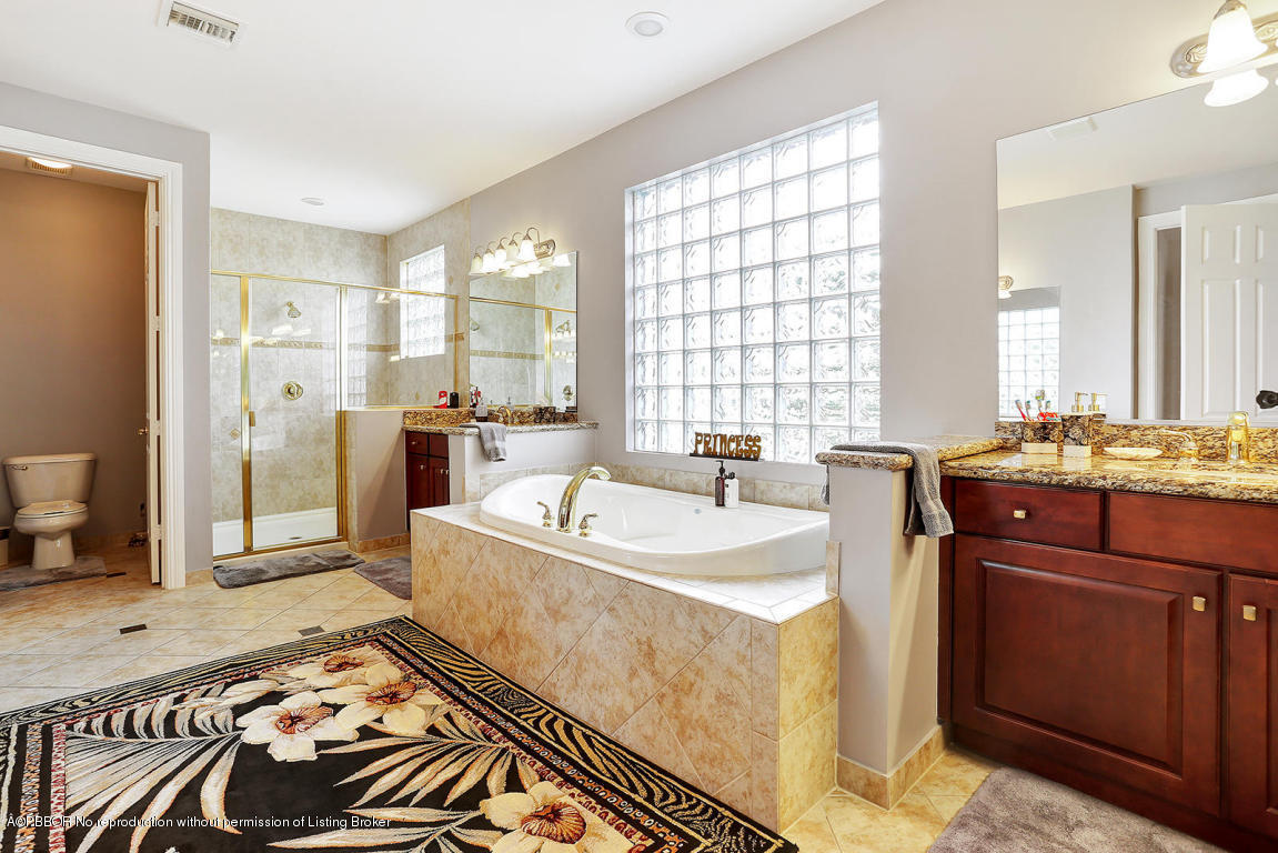 9831 Equus Circle Boynton Beach, FL 33472 - Photo 27 of 44 a spacious bathroom with a bathtub sink and mirror