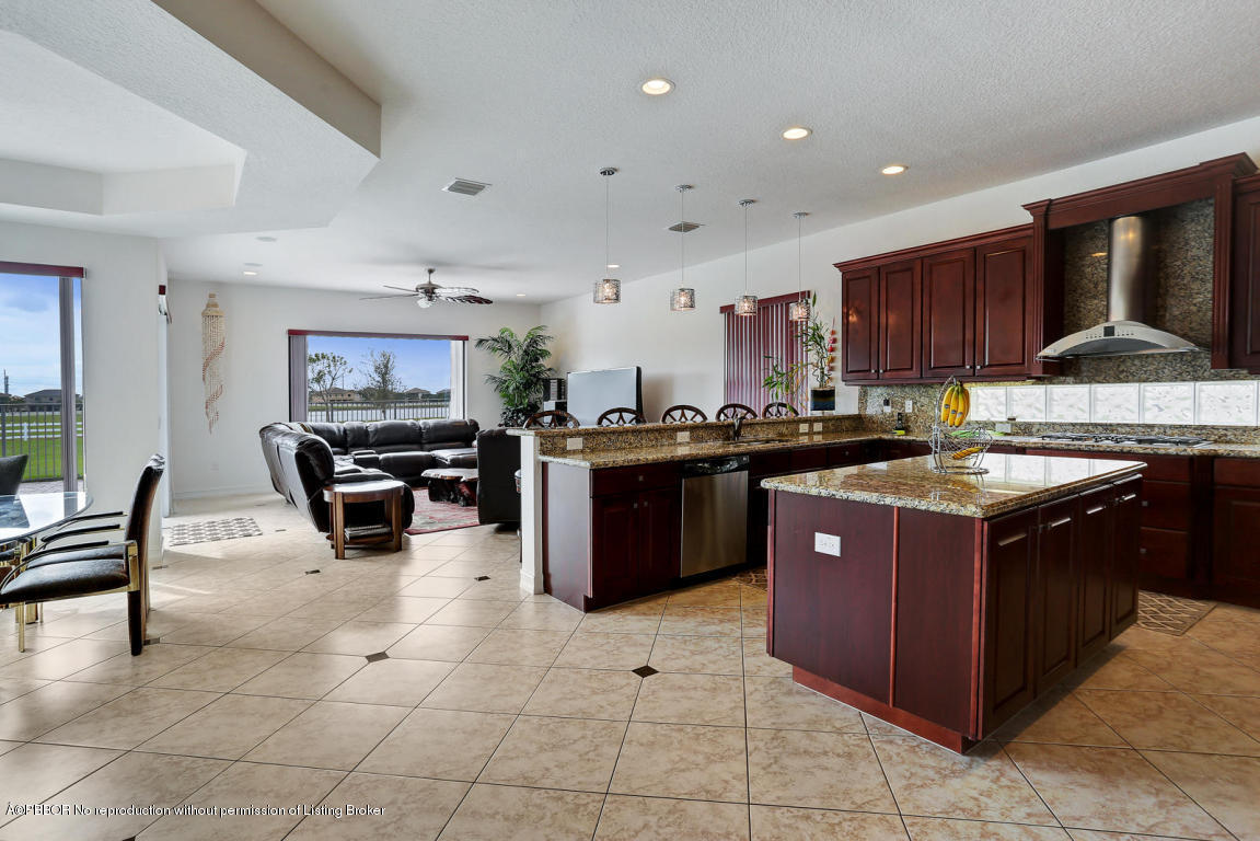 9831 Equus Circle Boynton Beach, FL 33472 - Photo 4 of 44 a kitchen with stainless steel appliances granite countertop a stove top oven a sink dishwasher and a refrigerator