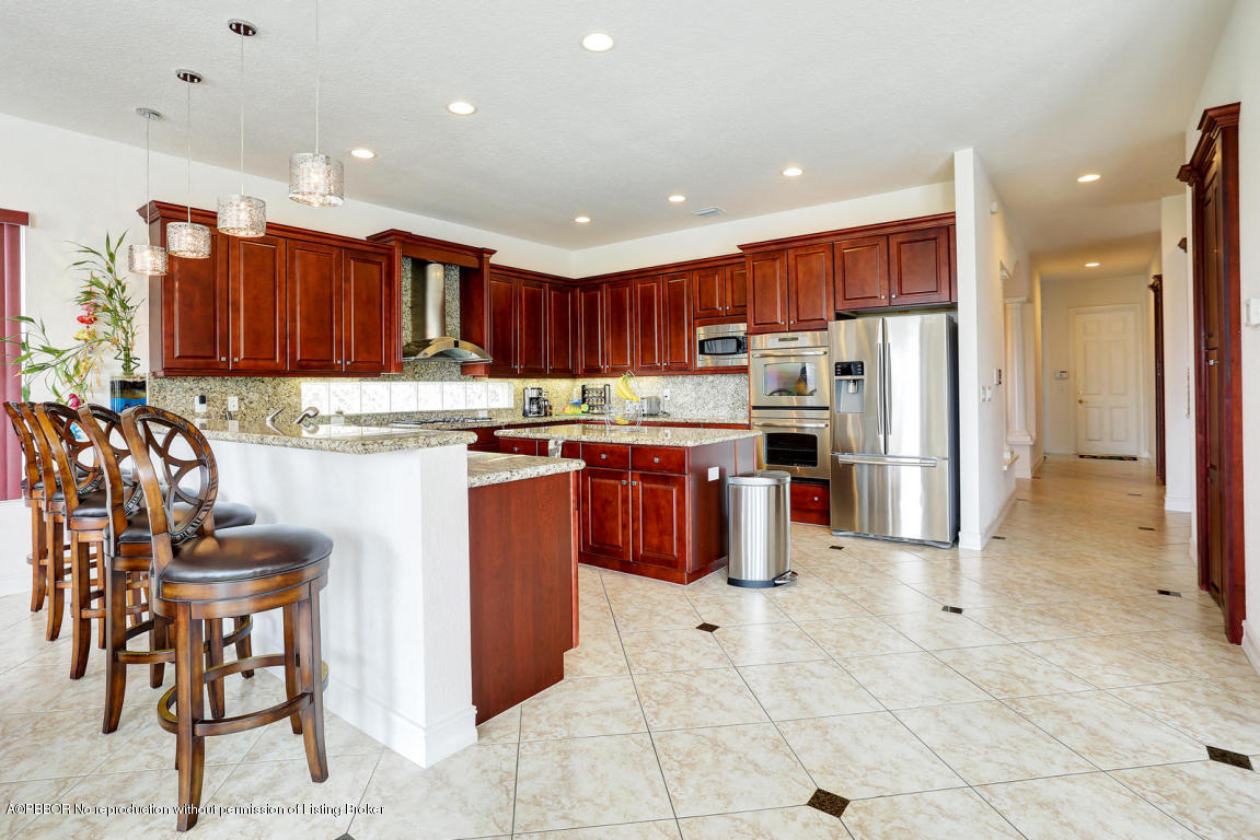 9831 Equus Circle Boynton Beach, FL 33472 - Photo 38 of 44 a kitchen with stainless steel appliances granite countertop a stove top oven a sink dishwasher and a refrigerator with cabinets