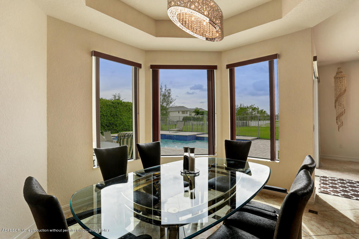 9831 Equus Circle Boynton Beach, FL 33472 - Photo 40 of 44 a view of a dining room with furniture large windows and wooden floor