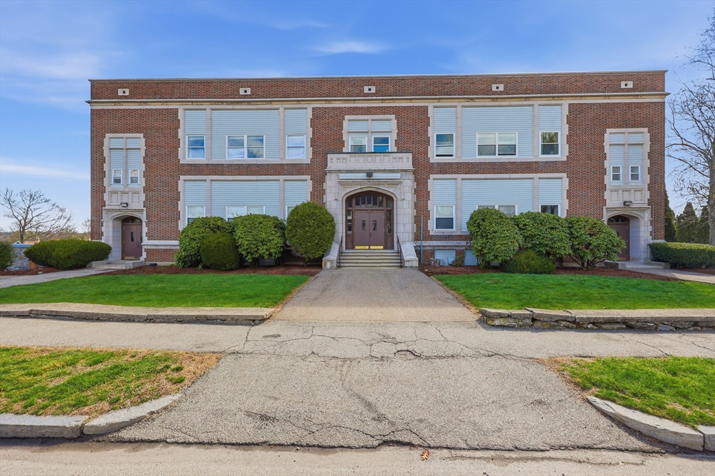 a front view of a house with a garden and plants