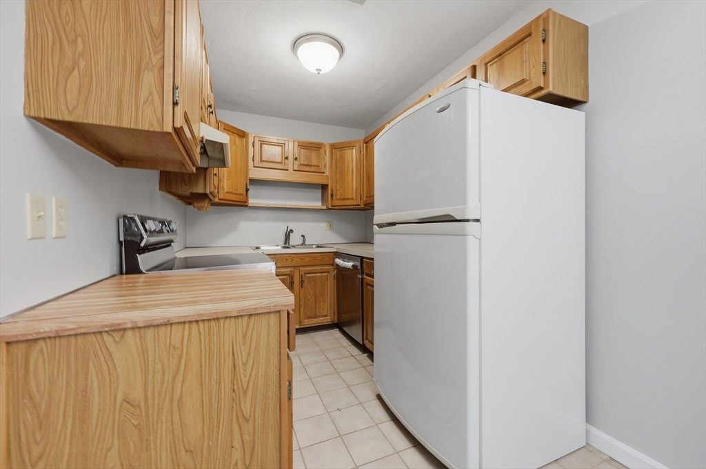 21 Middlesex Avenue, Unit 305 Worcester, MA 01604 - Photo 12 of 27 a kitchen with a refrigerator a stove top oven a sink and dishwasher