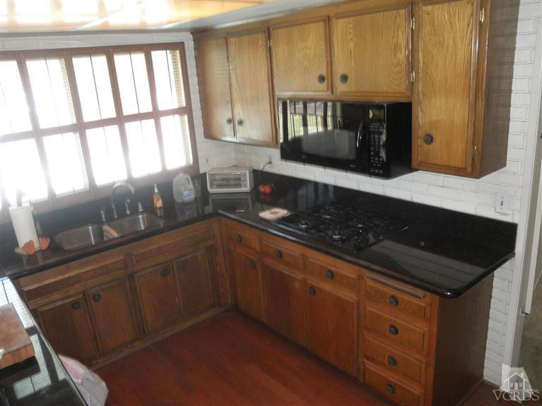4181 Springfield Street Simi Valley, CA 93063 - Photo 7 of 13 a kitchen with granite countertop a sink a stove and cabinets