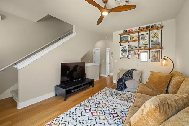 a living room with furniture a flat screen tv and a window