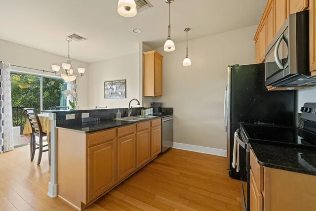 a kitchen with stainless steel appliances granite countertop a sink a stove and a refrigerator