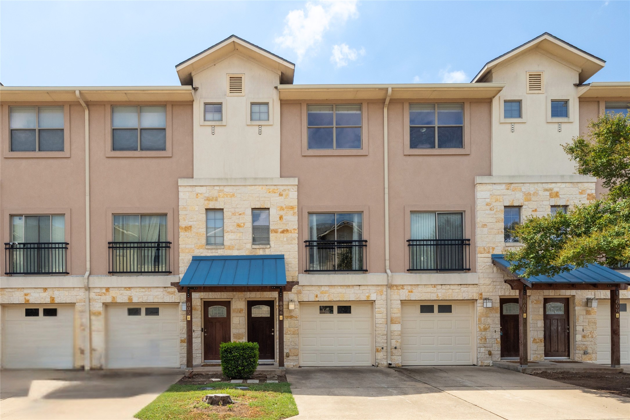 13420 Lyndhurst Street, Unit 806 Austin, TX 78717 - Photo 2 of 24 View of front of house featuring stone siding, driveway, an attached garage, and stucco siding