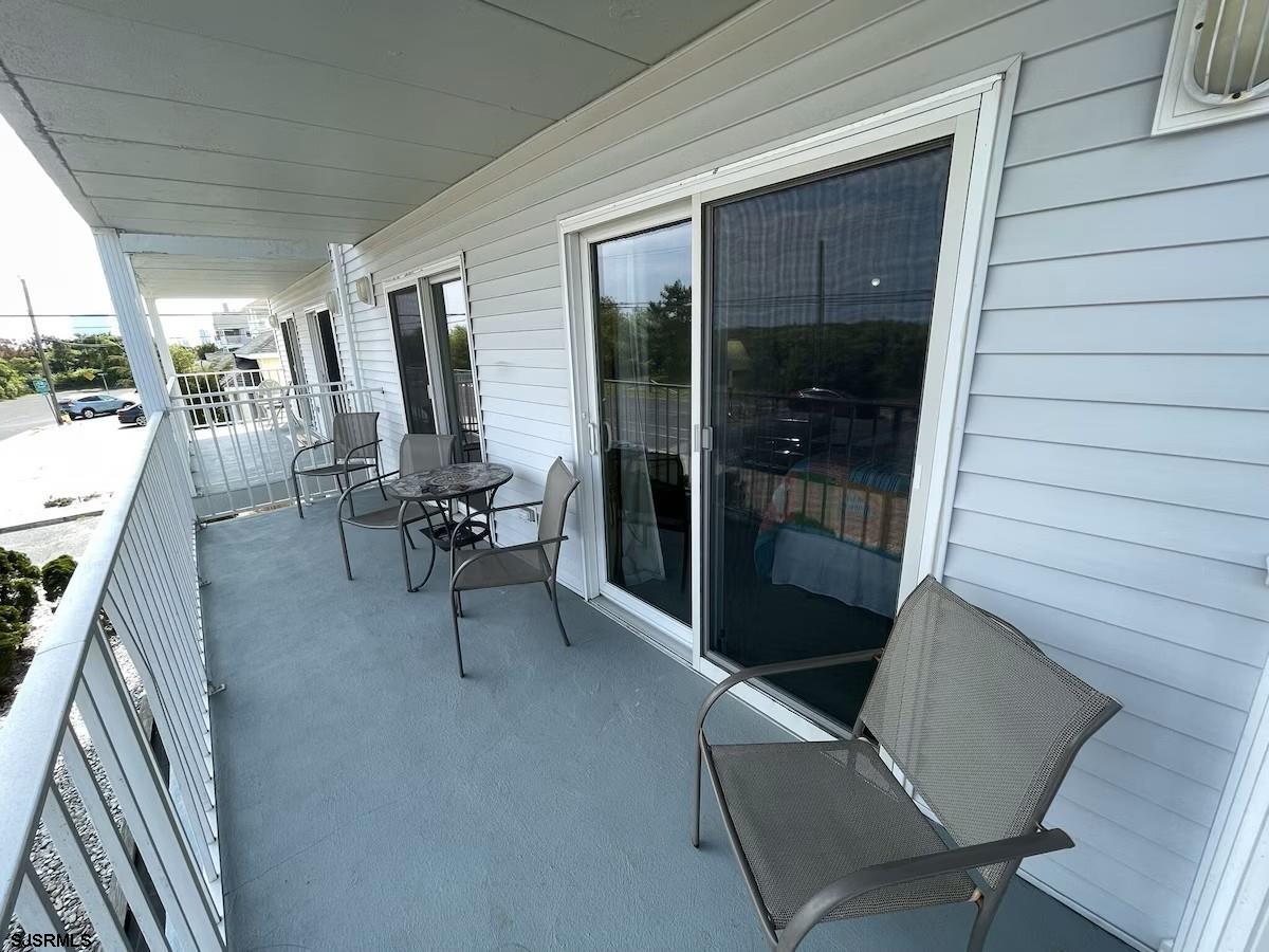 3901 Ocean Avenue, Unit 2 Brigantine, NJ 08203 - Photo 19 of 22 a view of a porch with chairs and floor to ceiling window