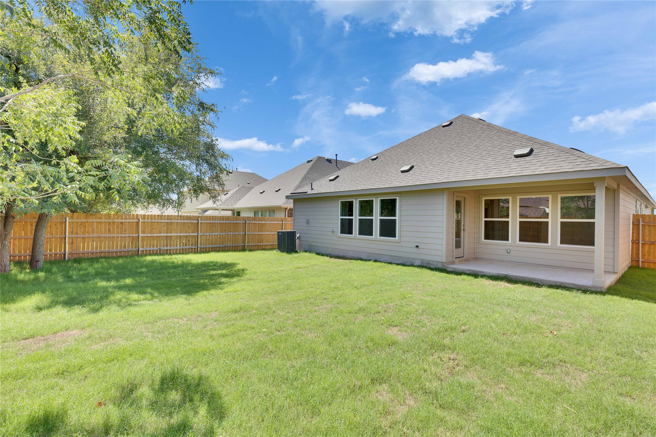 13509 Barn Chime Street Elgin, TX 78621 - Photo 33 of 40 Expansive green lawn with a wood privacy fence