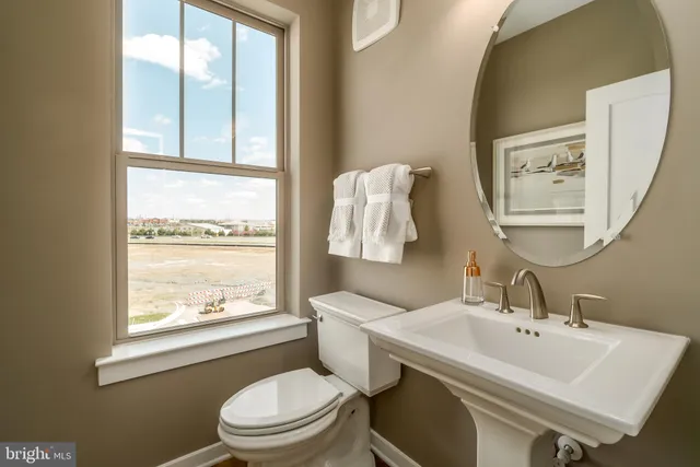 a bathroom with a sink a toilet and a window