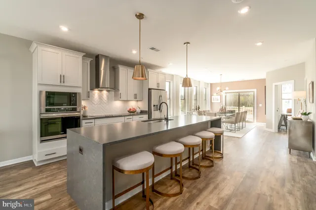 a large kitchen with kitchen island a large window a sink and stainless steel appliances