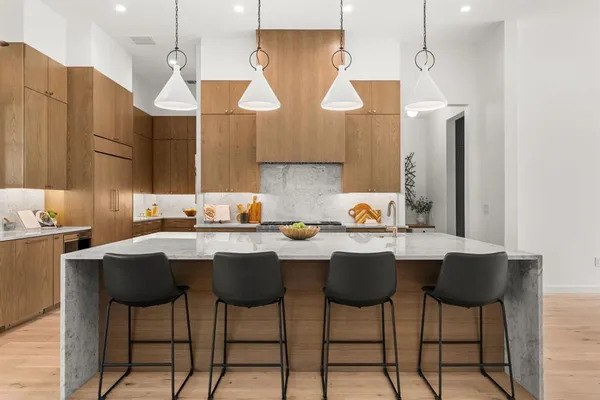 a kitchen with a dining table chairs sink and granite counter tops
