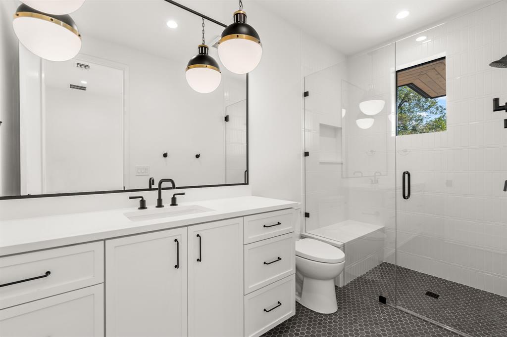 5908 Bull Creek Road Austin, TX 78757 - Photo 29 of 36 a bathroom with a toilet sink double vanity and mirror