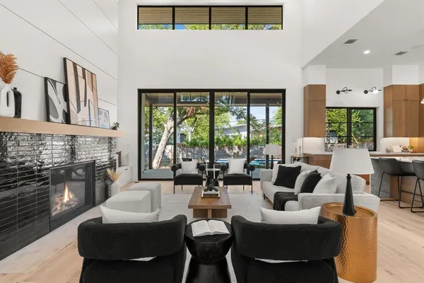 a living room with fireplace furniture and a large window