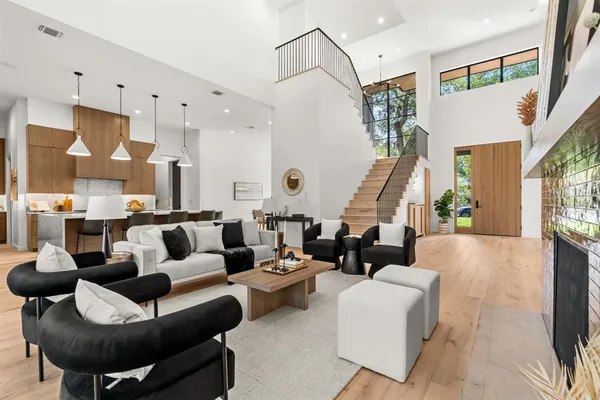 a living room with furniture kitchen view and a large window
