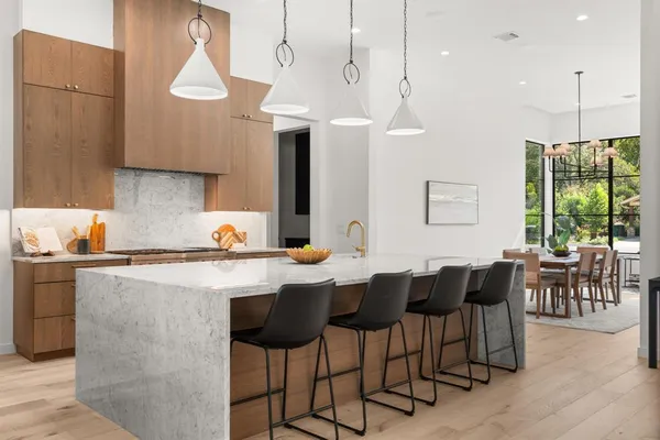a kitchen with a dining table chairs sink and white cabinets