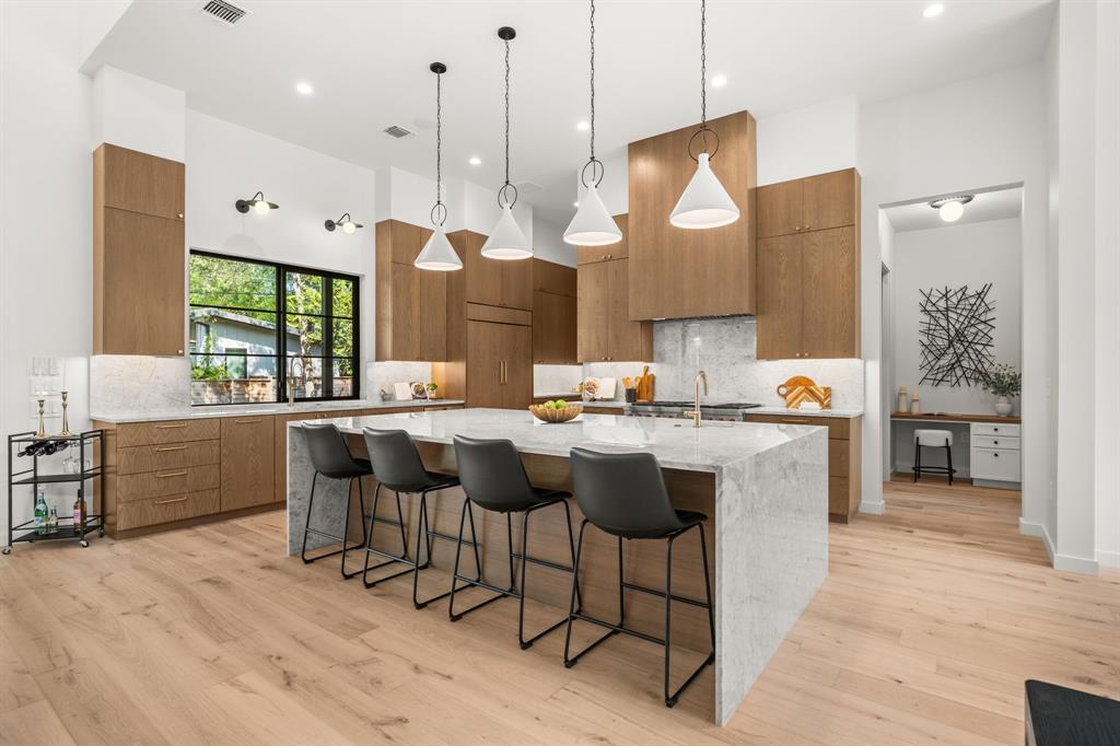 5908 Bull Creek Road Austin, TX 78757 - Photo 10 of 36 a kitchen with stainless steel appliances granite countertop a sink a stove a refrigerator and island with wooden floor