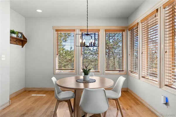 a dining room with furniture a chandelier and wooden floor