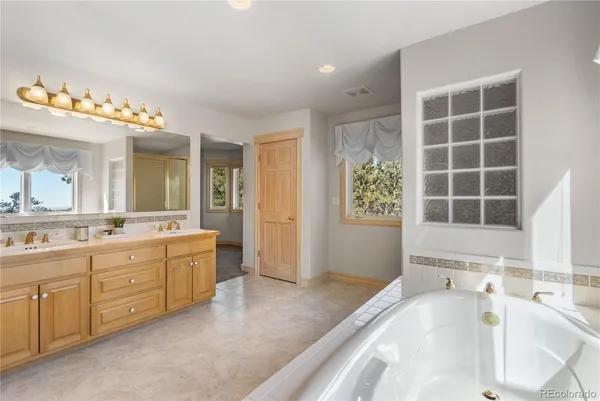 a spacious bathroom with a tub sink and mirror