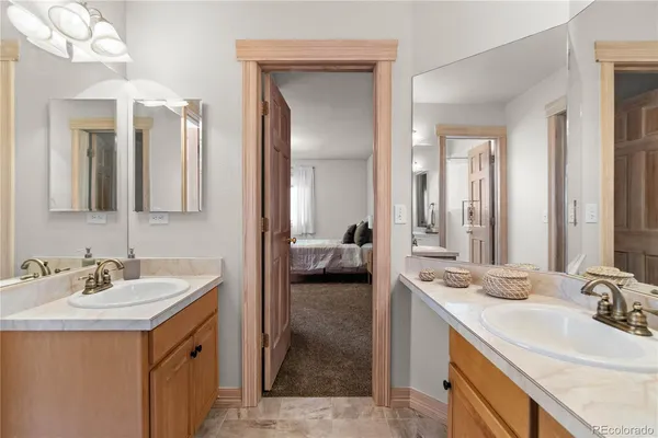 a en suite bathroom with a double vanity sink and a mirror