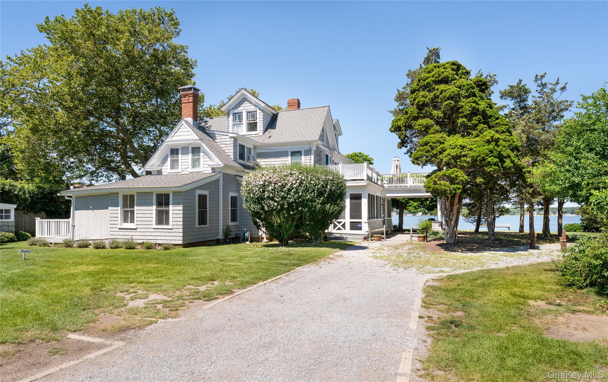 a front view of a house with a garden and trees