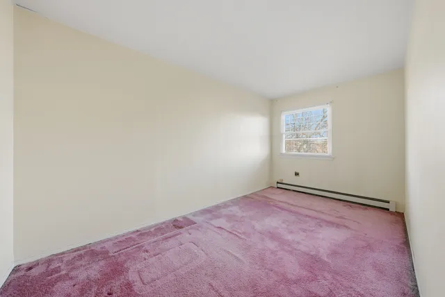 an empty room with windows and fireplace