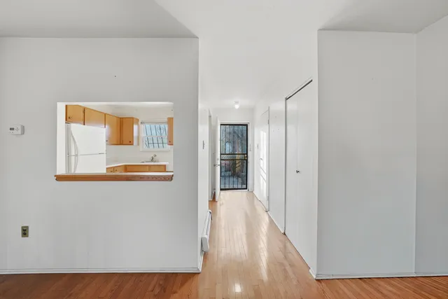 a view of a workspace with wooden floor and a window