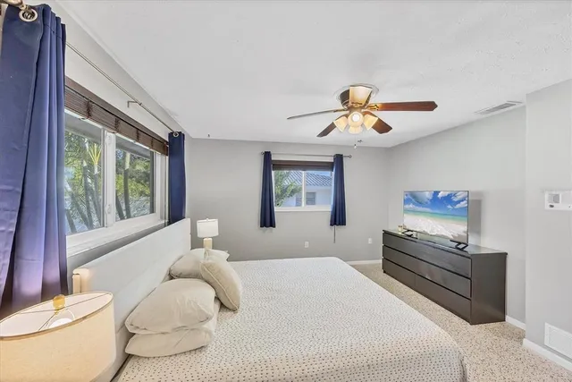 a bedroom with a bed and a large window