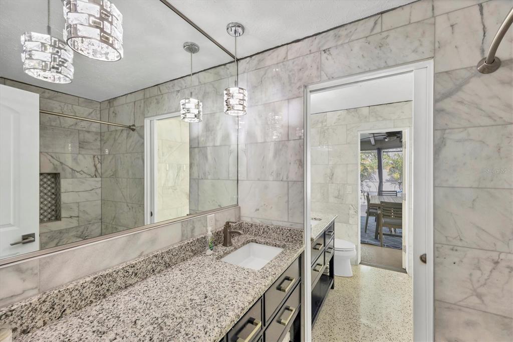 2927 Webber Street Sarasota, FL 34239 - Photo 13 of 27 a bathroom with a granite countertop sink a mirror and a shower