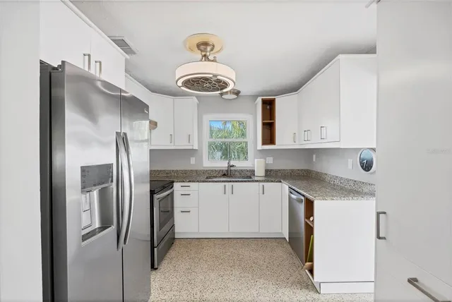 a kitchen with stainless steel appliances granite countertop a sink and refrigerator
