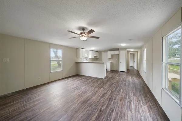 a view of a big room with wooden floor and windows