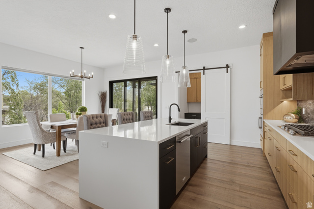 653 East Vandalay Lane Draper, UT 84020 - Photo 19 of 61 Kitchen featuring a white waterfall island with an undermount sink and pendant lighting