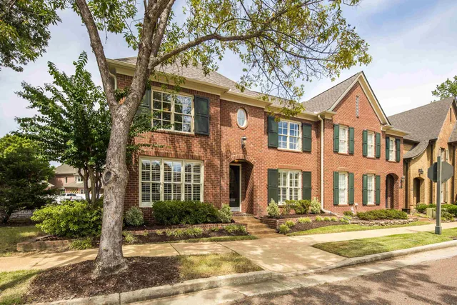 a front view of a residential apartment building with a yard