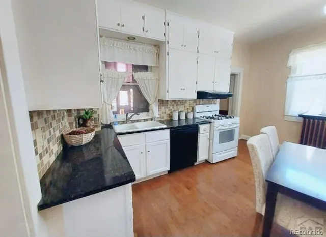 a kitchen with stainless steel appliances a white table chairs and a refrigerator