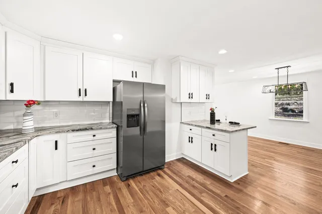 a kitchen with granite countertop a sink cabinets and stainless steel appliances