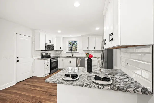 a kitchen with a refrigerator a stove top oven a sink and cabinets