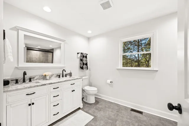 a bathroom with a toilet sink and mirror