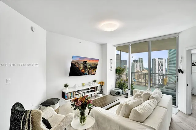 a living room with furniture a flat screen tv and a large window