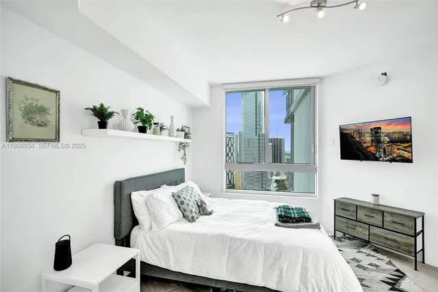 a bedroom with a bed and a flat screen tv