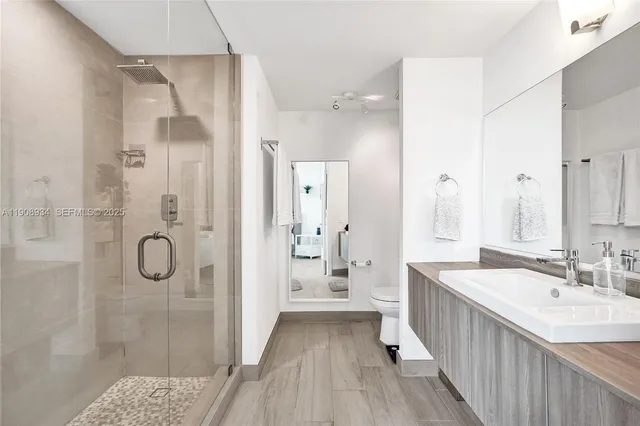 a bathroom with a shower sink and mirror