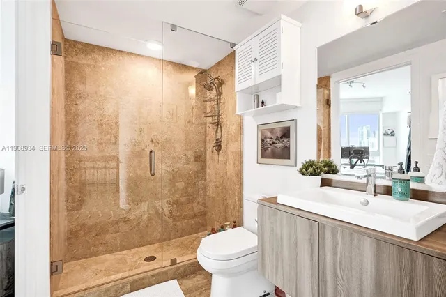 a bathroom with a double vanity sink toilet and shower