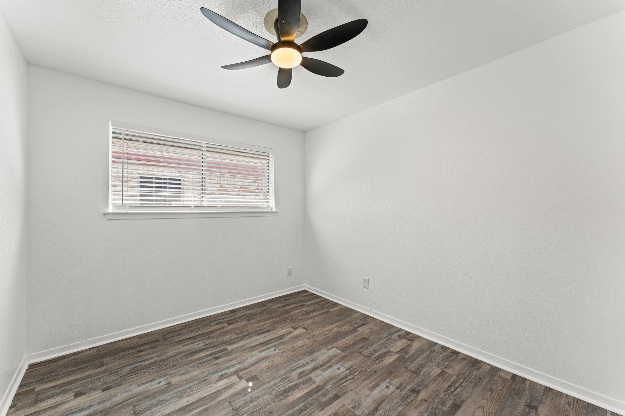 4519 Anice Street Houston, TX 77039 - Photo 11 of 25 an empty room with wooden floor and windows