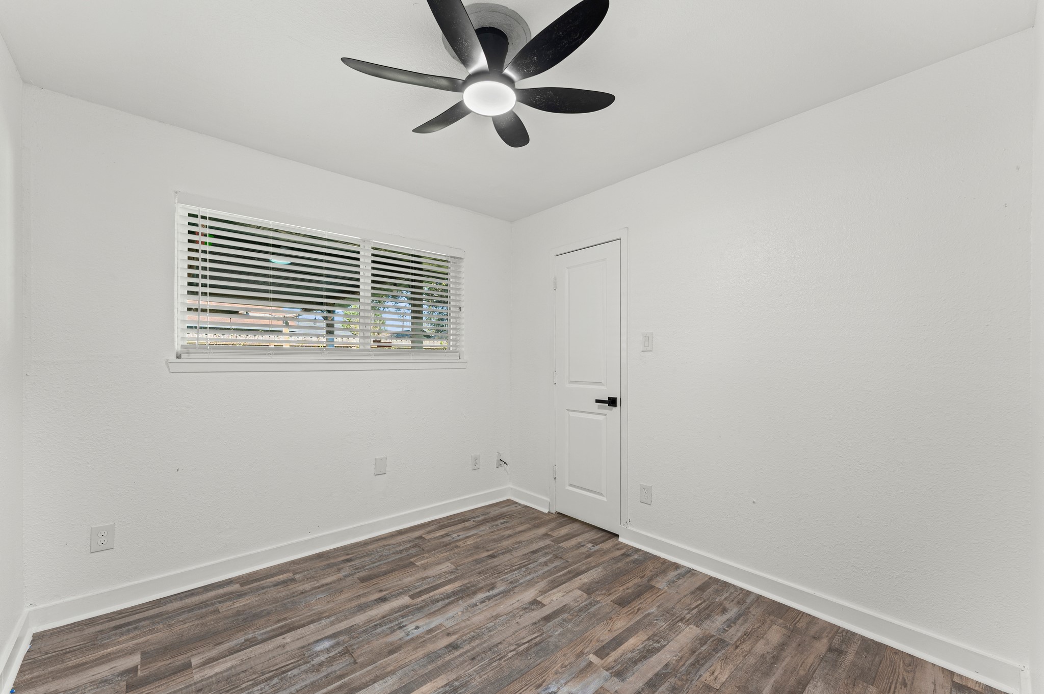 4519 Anice Street Houston, TX 77039 - Photo 12 of 25 a view of an empty room with wooden floor and a ceiling fan