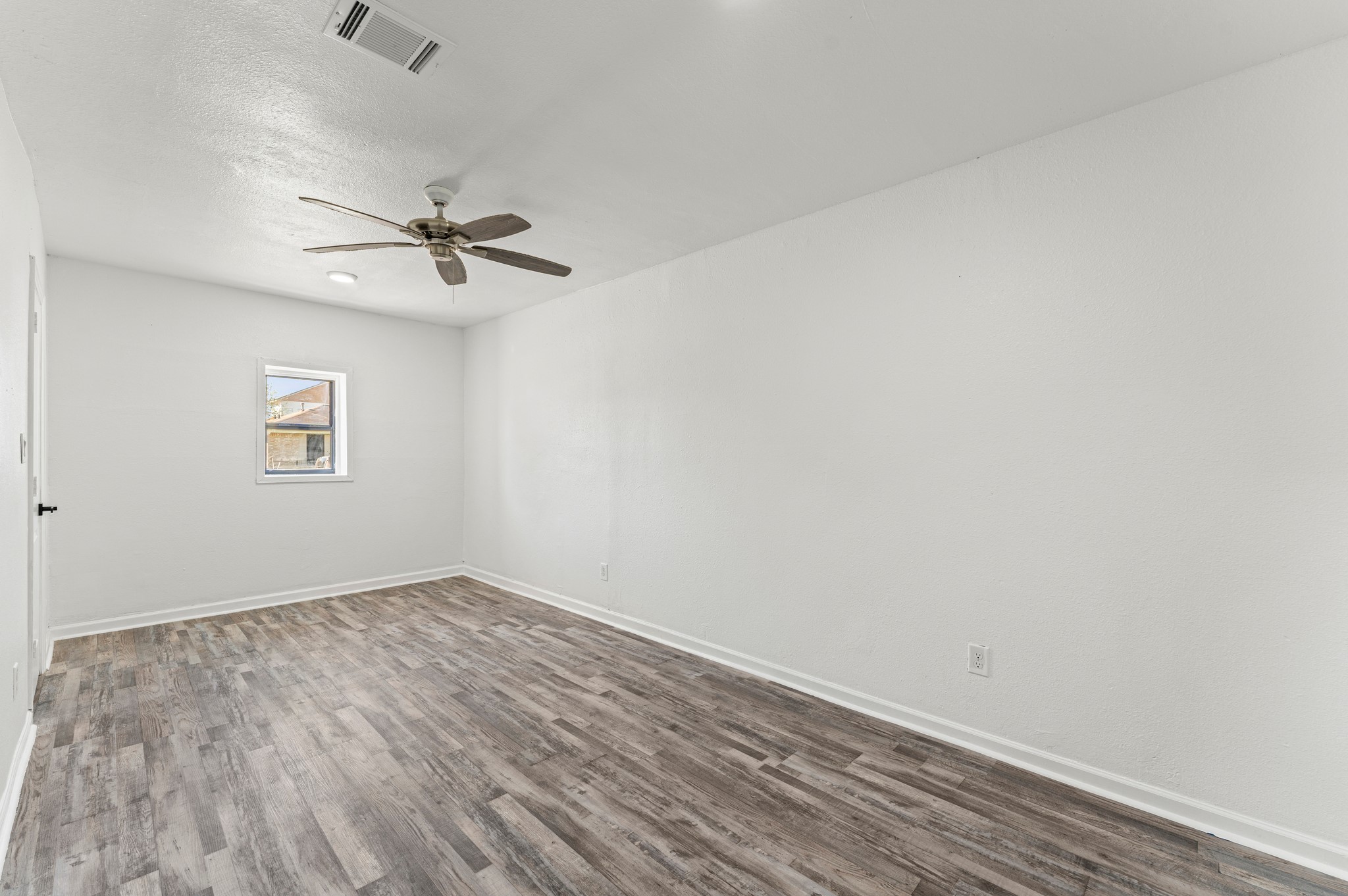 4519 Anice Street Houston, TX 77039 - Photo 10 of 25 an empty room with a window and a ceiling fan
