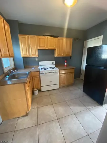 a kitchen with a stove top oven cabinets and a refrigerator