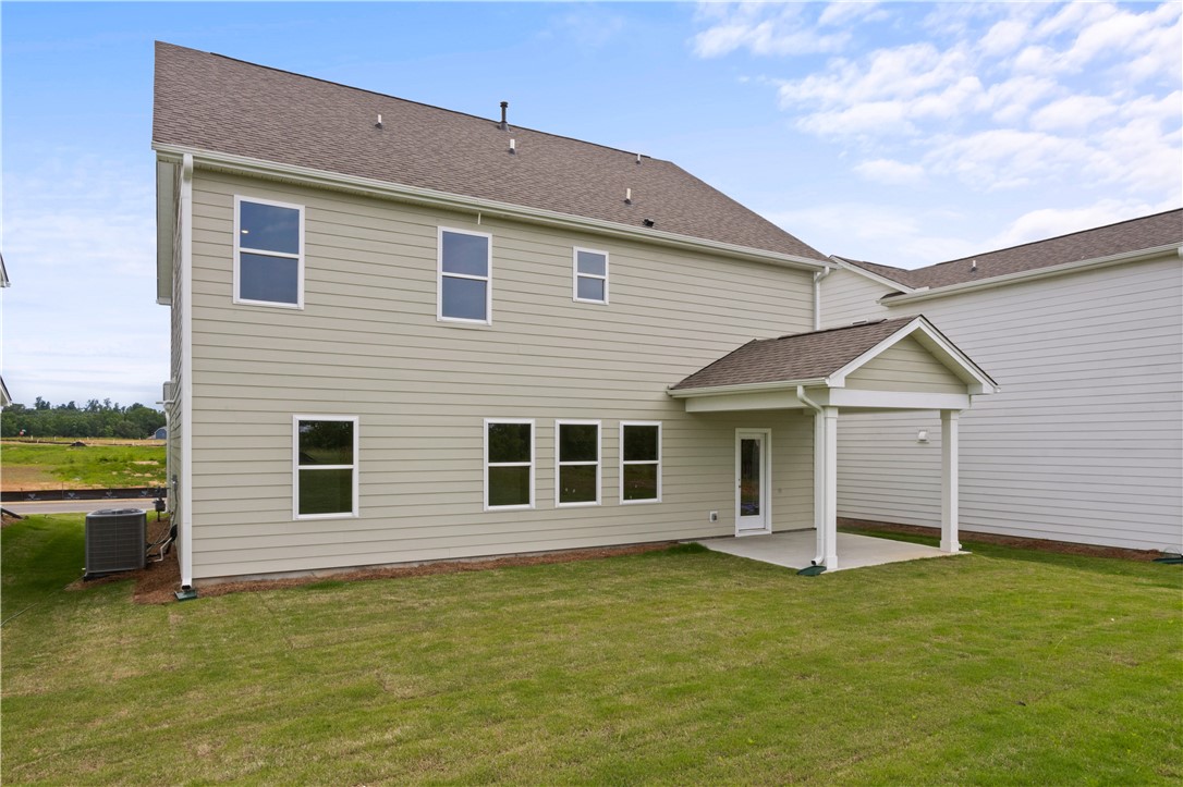 555 Hydrangea Street, Unit LOT 47 Seneca, SC 29678 - Photo 4 of 38 A well-maintained lawn stretches behind this inviting residence, featuring a covered patio perfect for outdoor relaxation.